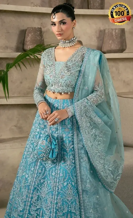 Embroidered teal lehenga for wedding guests with tassels and traditional finishing