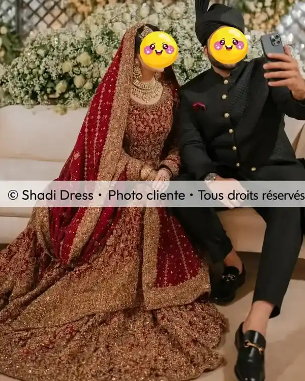 Mariée en lehenga rouge et doré assise aux côtés du marié en sherwani noire traditionnelle