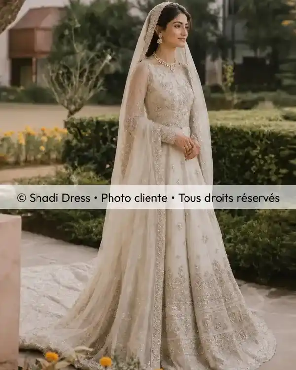 Mariée en robe ivoire élégamment brodée avec long voile lors de son mariage