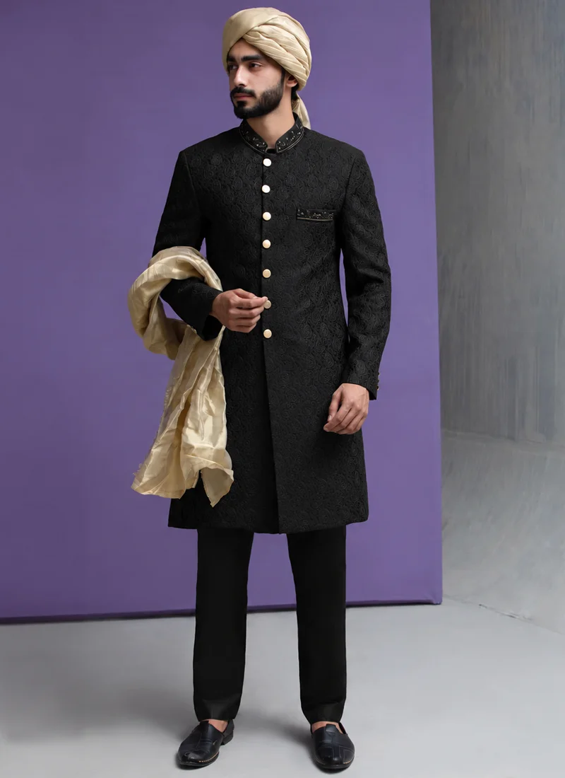 Pakistani black sherwani for groom with gold turban and coordinated shawl