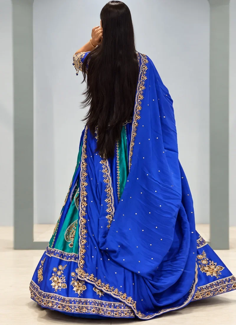 Royal blue bridal lehenga with teal green accents and colourful traditional motif detailing