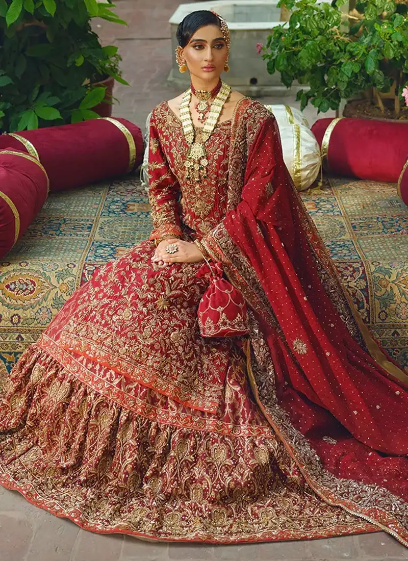Deep red bridal lehenga set with tissue silk shirt, chiffon dupatta, gold and copper work and almond motifs near the hem