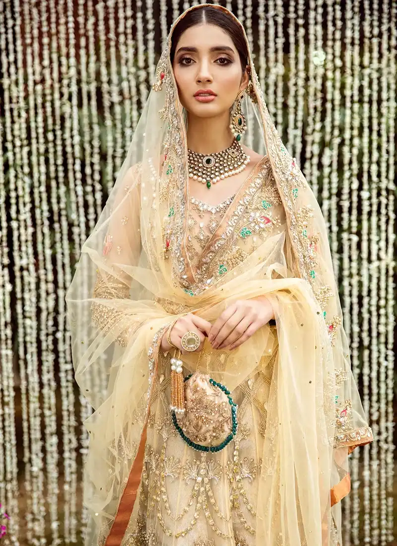Champagne gold pishwas side close-up with sheer dupatta and peach floral sleeve motif