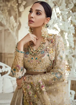 Champagne bridal lehenga choli close-up with antique gold embroidery, teal floral motifs and sheer dupatta