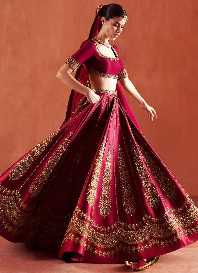 Deep Red Baraat Lehenga Choli with Antique Gold Floral Sprays Deep red bridal lehenga choli from the back, showing a deep rounded cut-out and antique gold floral embroidery.