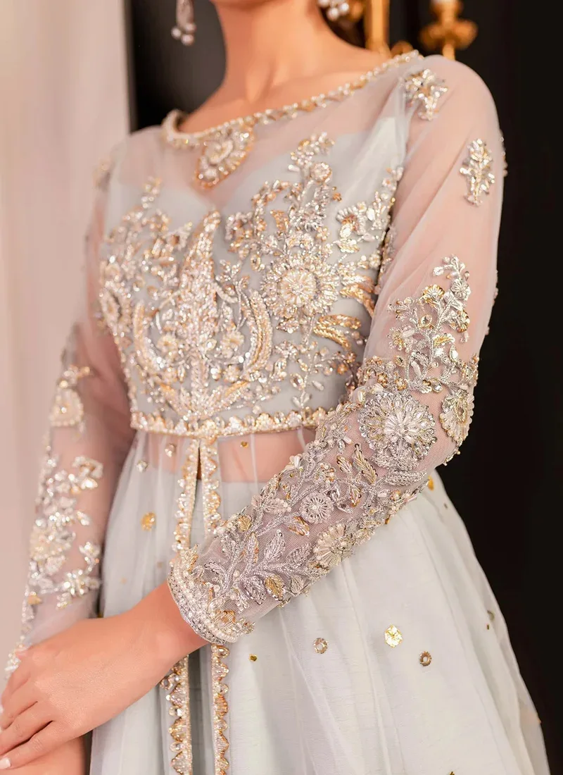 Ice blue gown bodice close-up with silver and gold floral embroidery and densely embellished net cuffs