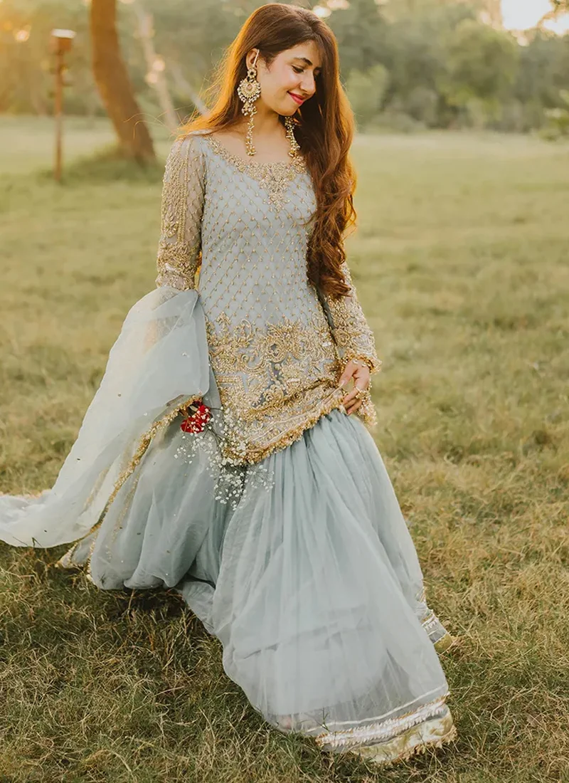 Ice blue gharara suit back view showing ornate gold shirt embroidery and a sheer gold-edged dupatta