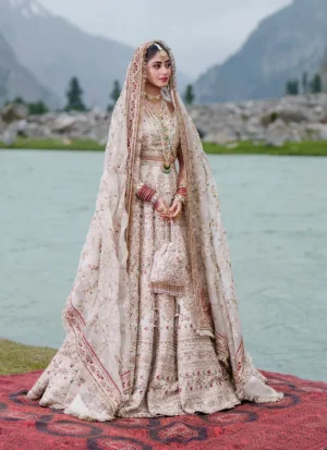 Full-length standing view of the ivory Baraat lehenga choli: cropped embellished choli, wide embroidered ghera and sheer dupatta with maroon kiran-lace borders