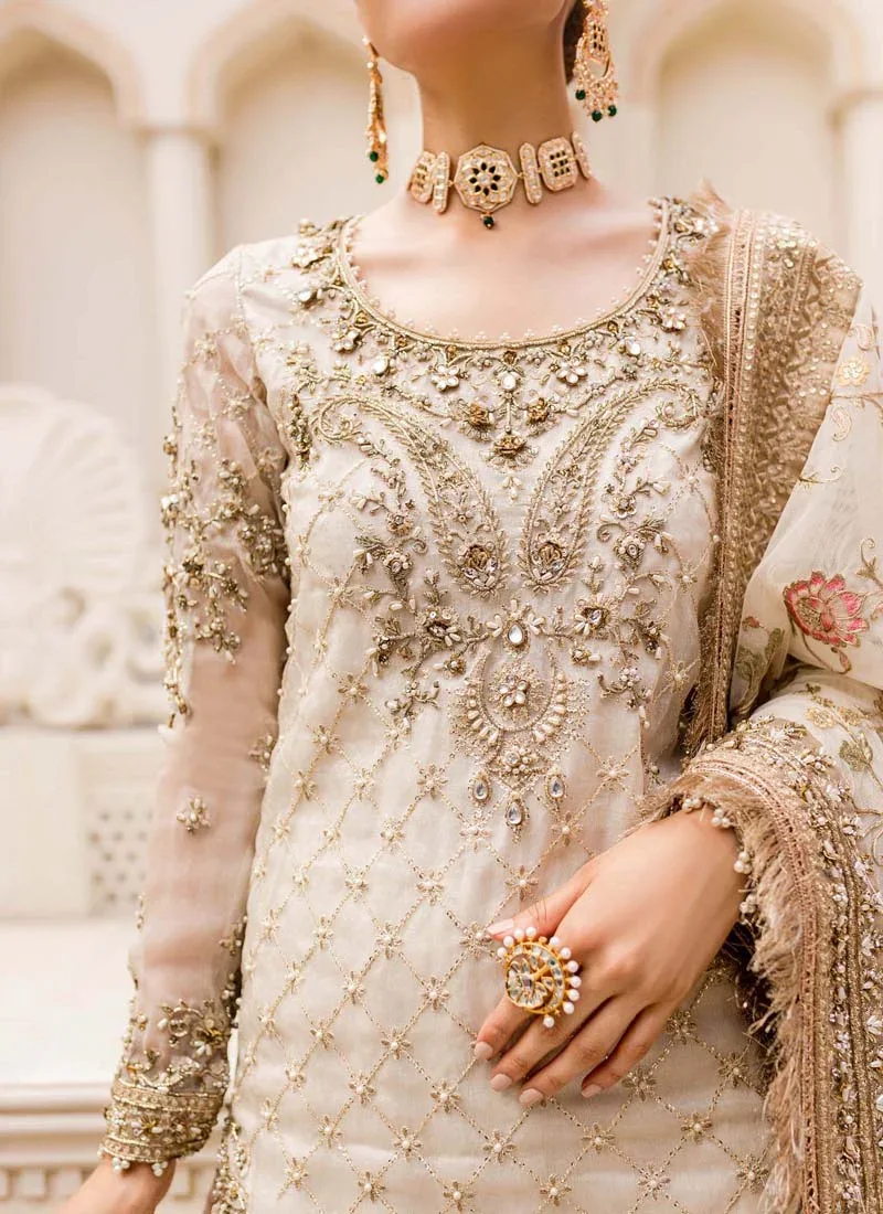 Ivory gharara suit front view with gold-embroidered kurti, flared bottoms and floral dupatta