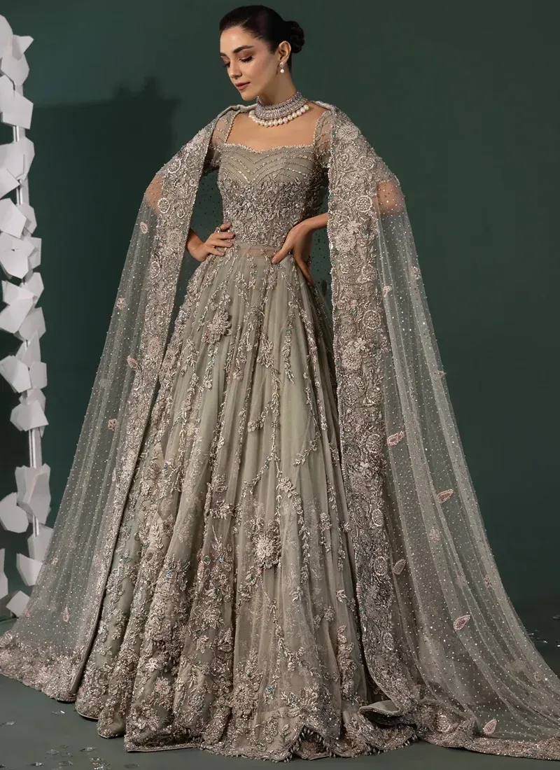 Sage green bridal gown full-length view showing its flared skirt, floral embroidery and richly embellished hem.